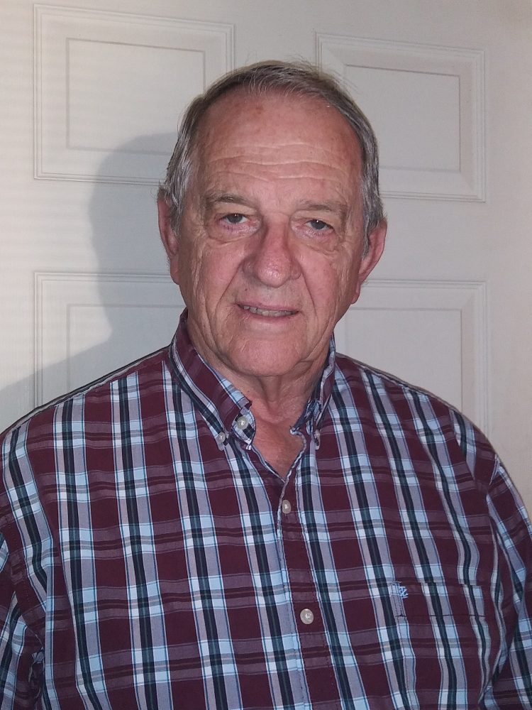 Photo of Earl Lawson in red plaid shirt, smiling to camera.